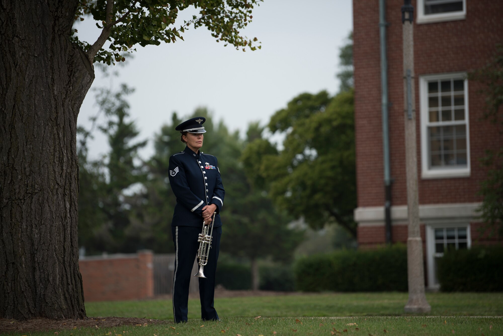 Airman stands under tree