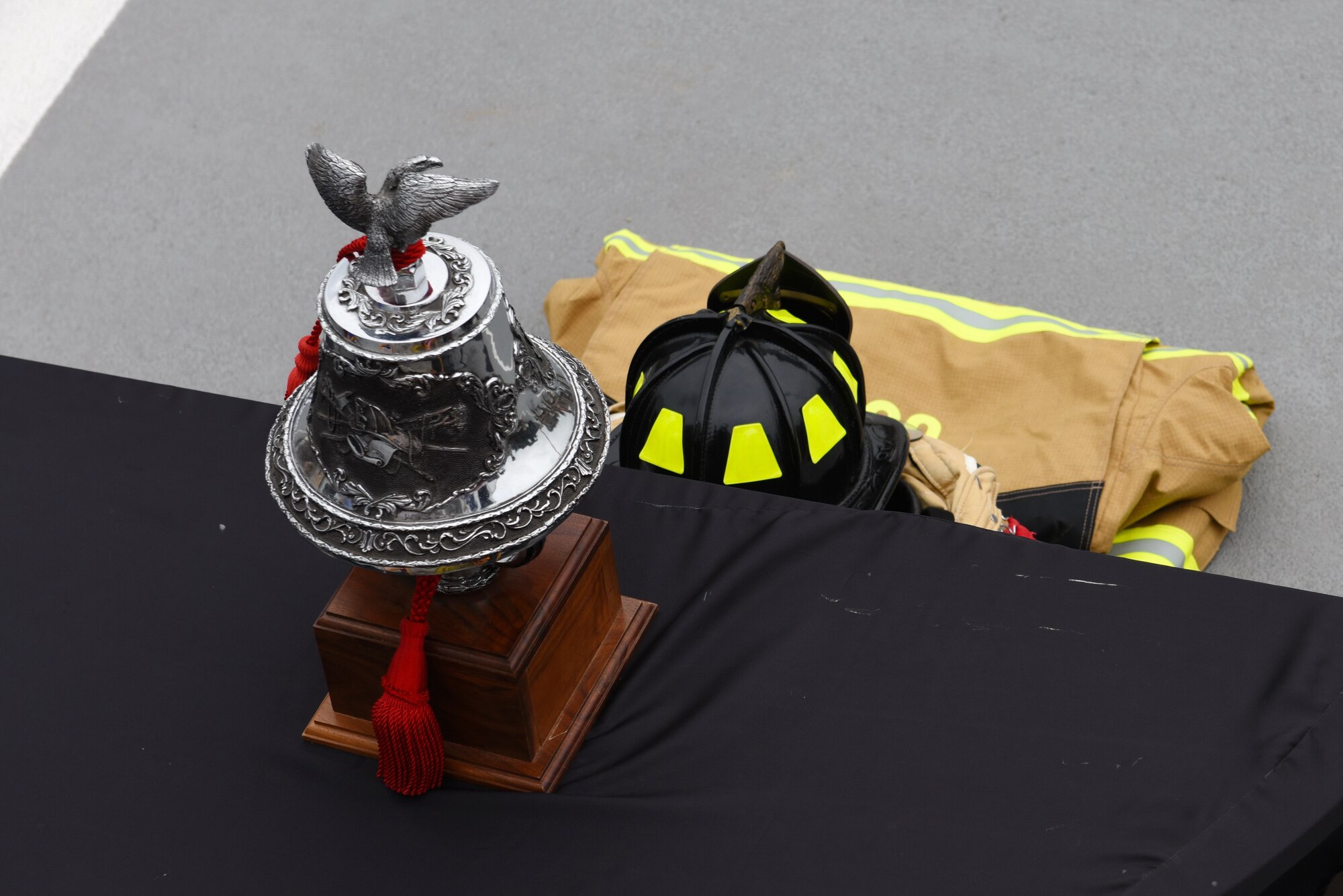 A ceremonial bell and firefighter gear displays at Osan Air Base, Republic of Korea, Sept. 11, 2020. Patriot Day commemorates the men and women who lost their lives during the 9/11 attacks on the World Trade Center, Pentagon and Flight 93 and in battles against Al-Qaeda which followed. (U.S. Air Force photo by Senior Airman Branden Rae)