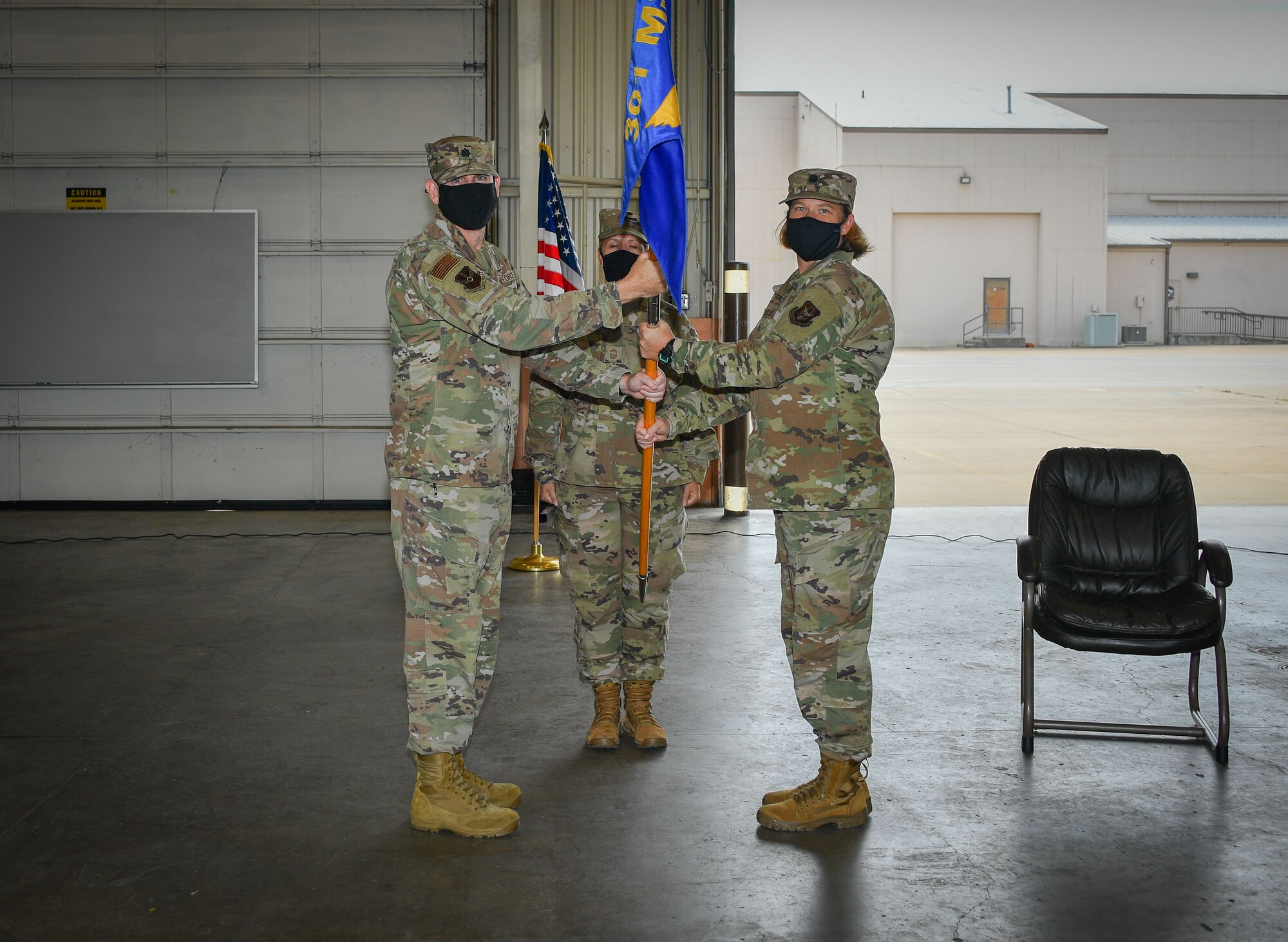 (Left to right) Lt. Col. Jeremy Moore, 301st Mission Support Group, deputy commander, hands the 301 FW LRS guidon to Lt. Col. Farrah Schluter during the 301st Fighter Wing Logistics Readiness Squadron Assumption of Command, September 13, 2020, at U.S. Naval Air Station Joint Reserve Base Fort Worth, Texas. The ceremony was limited to in-person personnel but also shared live on social media due to CDC protections. (U.S. Air Force photo by Staff Sgt. Randall Moose)