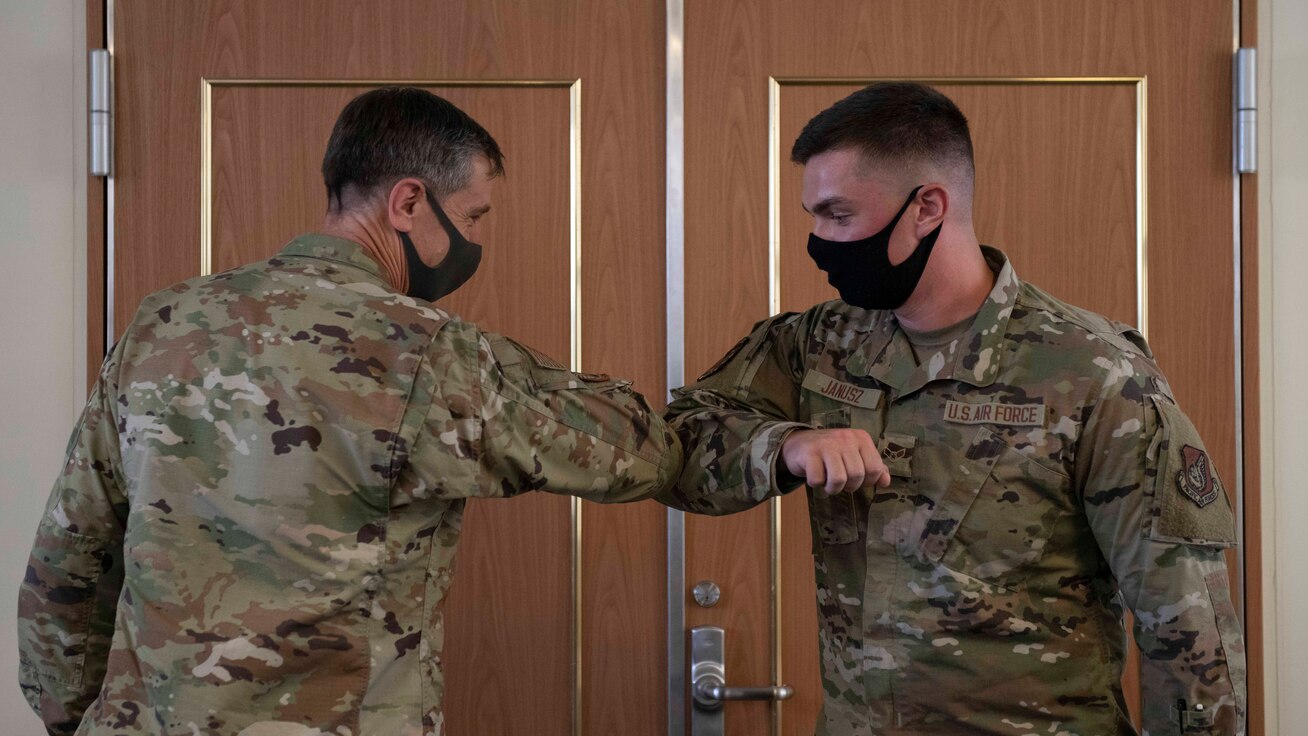 U.S. Air Force Lt. Gen. Kevin B. Schneider, U.S. Forces Japan and Fifth Air Force commander, and Airman 1st Class Jacob Janusz, 18th Aircraft Maintenance Squadron assistant dedicated crew chief, bump elbows during a recognition event Sept. 11, 2020, at Kadena Air Base, Japan. Lt. Gen. Schneider visited Team Kadena in order to communicate headquarters strategies directly to Team Kadena as well as receive feedback and listen to Airmen’s concerns. (U.S. Air Force photo by Staff Sgt. Peter Reft)
