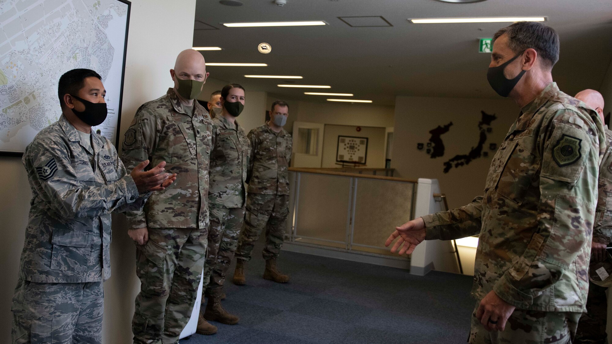 U.S. Air Force Tech. Sgt. Timothy Torres, 718th Civil Engineer Squadron unaccompanied housing non-commissioned officer in charge, catches a coin from Lt. Gen. Kevin B. Schneider, U.S. Forces Japan and Fifth Air Force commander, during a recognition event, Sept. 11, 2020, at Kadena Air Base, Japan. Lt. Gen. Schneider visited Team Kadena in order to engage with leaders about headquarters mission strategies, receive feedback on wing operations, and to give personal recognition to distinguished Airmen. (U.S. Air Force photo by Staff Sgt. Peter Reft)