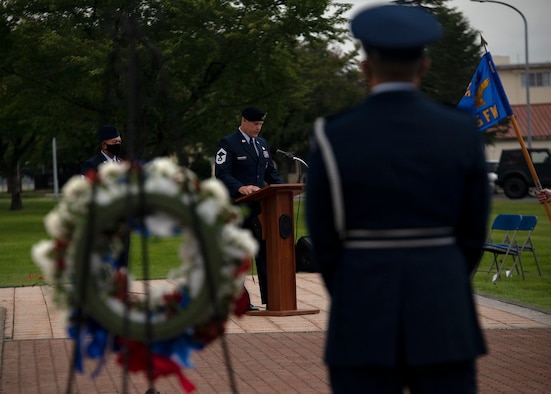 Individuals in uniform participate in an outdoor ceremony