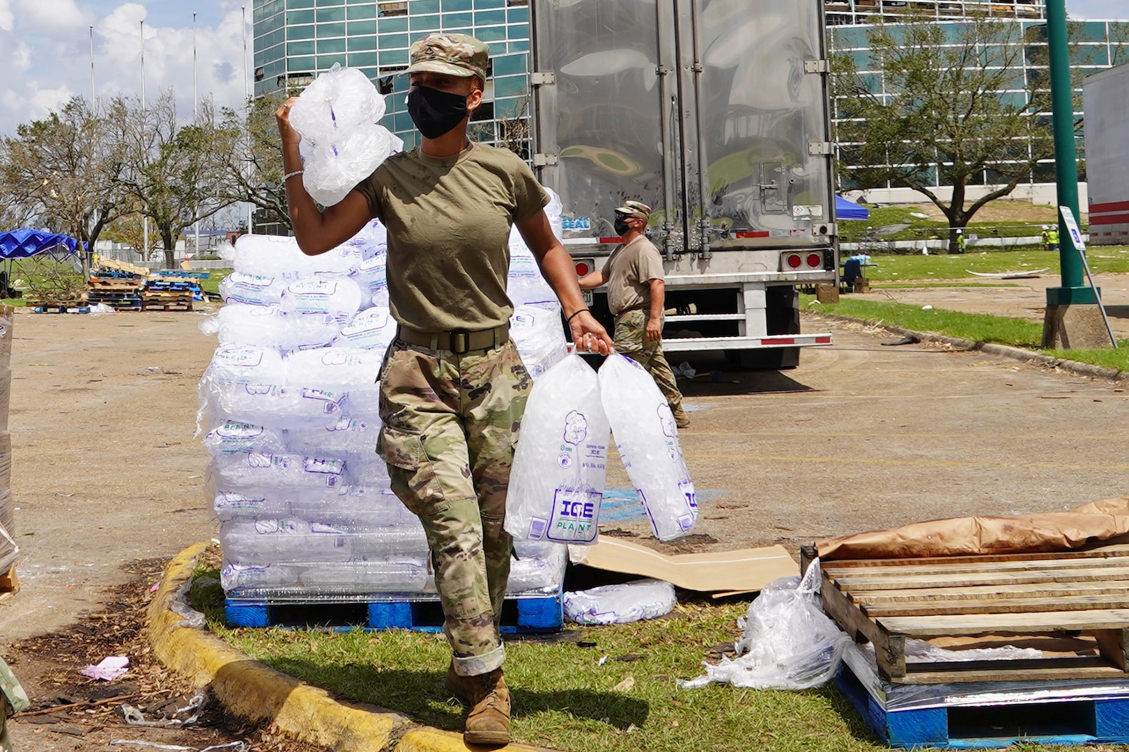 Louisiana National Guard Pfc. Reion Jones with the 1-141st Field Artillery Battalion, 256th Infantry Brigade Combat Team, hauls ice to a citizen's vehicle while working at a distribution site following Hurricane Laura in Lake Charles, Louisiana, Sept. 4, 2020.