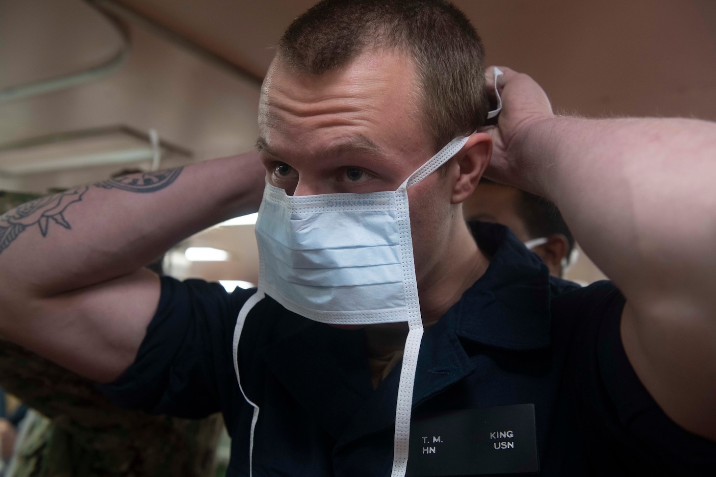 Hospitalman Thomas King dons a surgical mask during patient transport drills aboard hospital ship USNS Comfort (T-AH 20) as the ship prepares to admit patients in support of the nation’s COVID-19 response efforts.