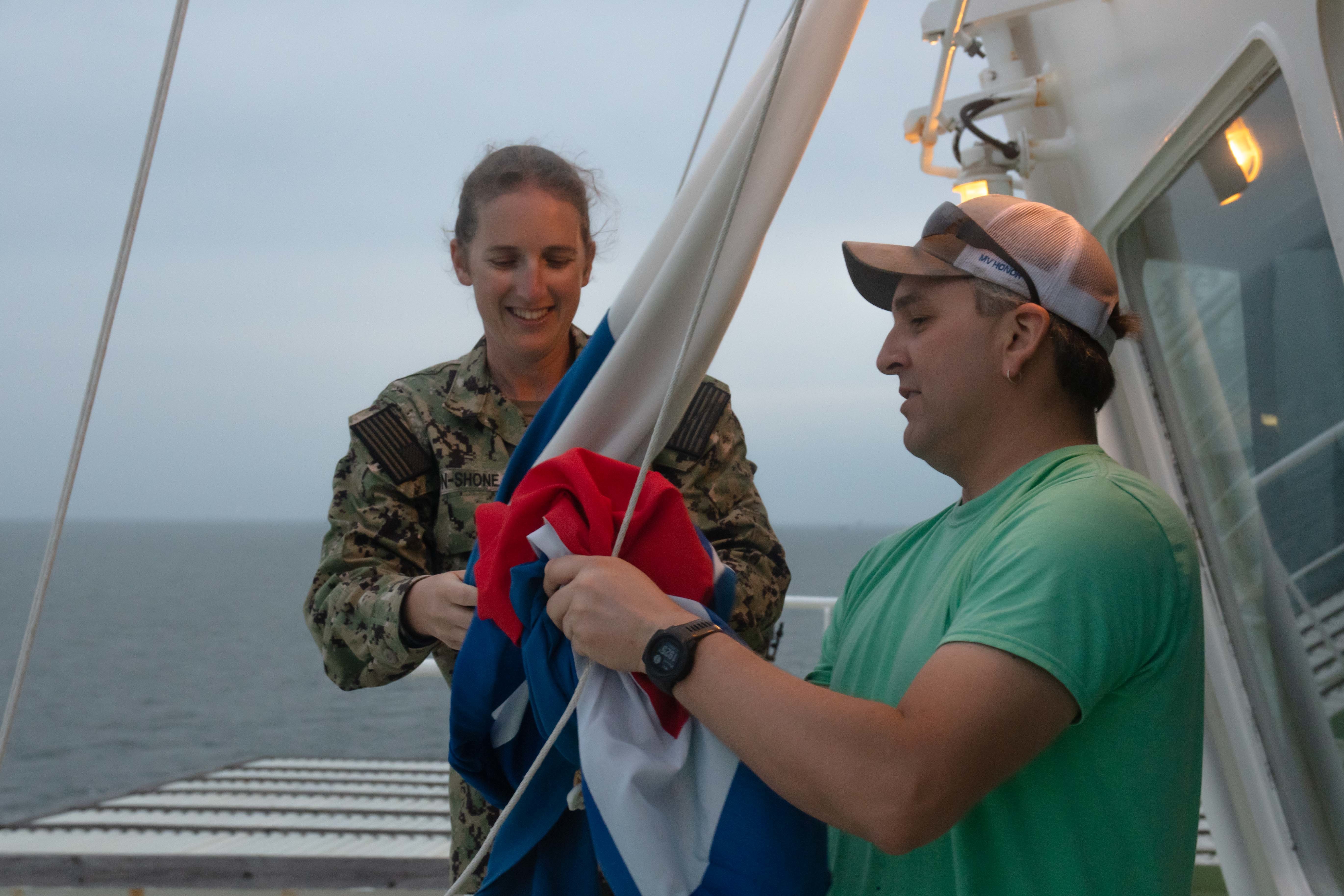 U.S. Navy Ens. Heather Bacon-Shone, Tactical Advisor (TACAD) with the Strategic Sealift Officer program, reviews tactical signaling with able-bodied seaman Joshua Sheldrick aboard the M/V Patriot during convoy operations in the Atlantic Ocean as part of DEFENDER-Europe 20.