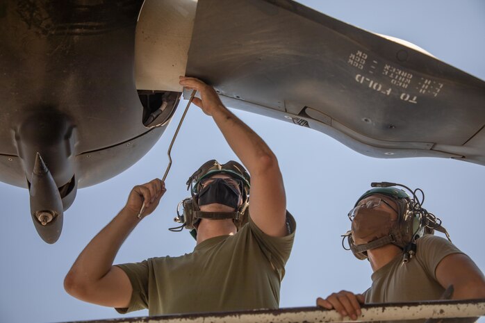 A U.S. Marine and a U.S. Navy Aviation Structural Mechanic Airman perform maintenance on a MV-22 Osprey in Kuwait, Aug. 5.