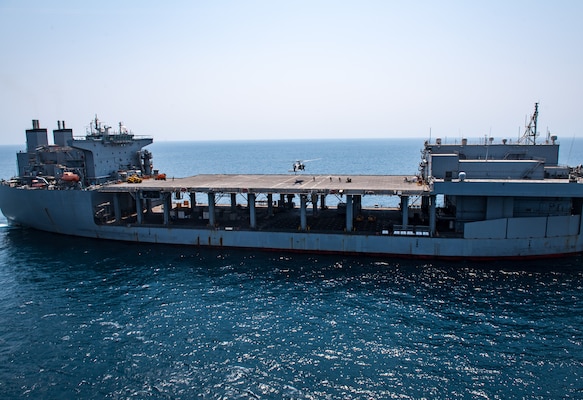 Explosive ordnance disposal technicians, assigned to Commander, Task Force (CTF) 56, fast-rope from an MH-60S Sea Hawk helicopter, attached to Helicopter Sea Combat Squadron (HSC) 26, onto the expeditionary mobile base USS Lewis B. Puller (ESB 3) during a fast-rope training evolution in the Arabian Gulf.