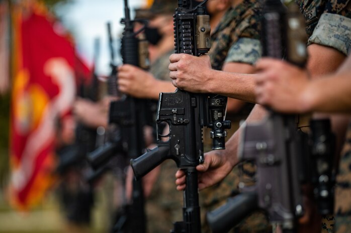 U.S. Marines present arms during a change of command ceremony on Camp Lejeune, N.C., Aug. 6.