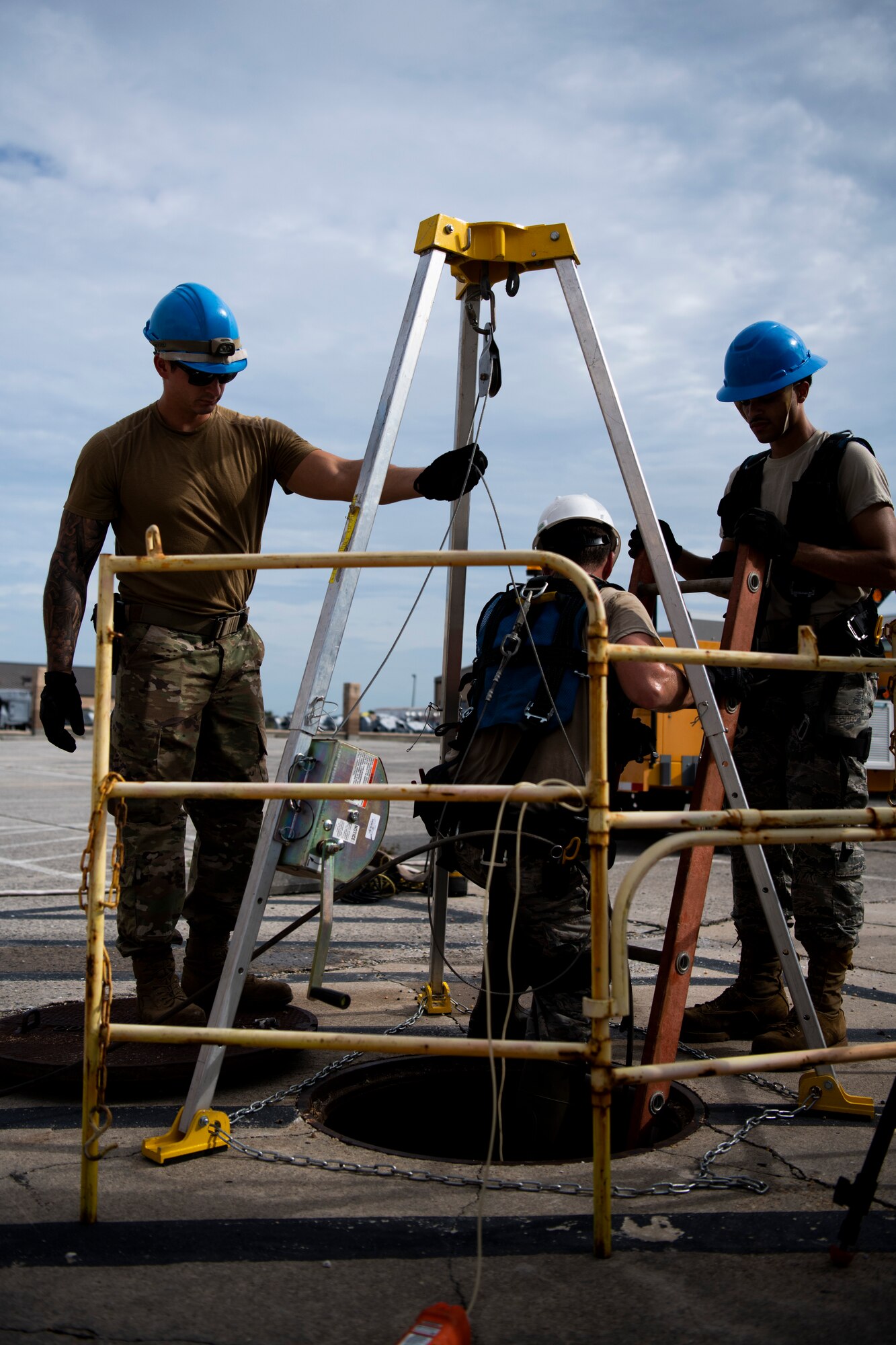 U.S. Air Force Senior Airman Trent Olson, left, Airman 1st Class Emmanuel Jackson-Wilson, right, cable antenna systems technicians with the 85th Engineering Installation Squadron assigned to Keesler Air Force Base, Mississippi, help Staff Sgt. Jesse Laclair (center), 85th EIS cable antenna systems technician, as he enters a manhole to work on underground cables at Tyndall Air Force Base, Florida, Aug. 28, 2020. The 85th EIS has made multiple trips to Tyndall to assist the 325th Communications Squadron with relocating information transfer nodes. (U.S. Air Force photo by Tech. Sgt. Clayton Lenhardt)