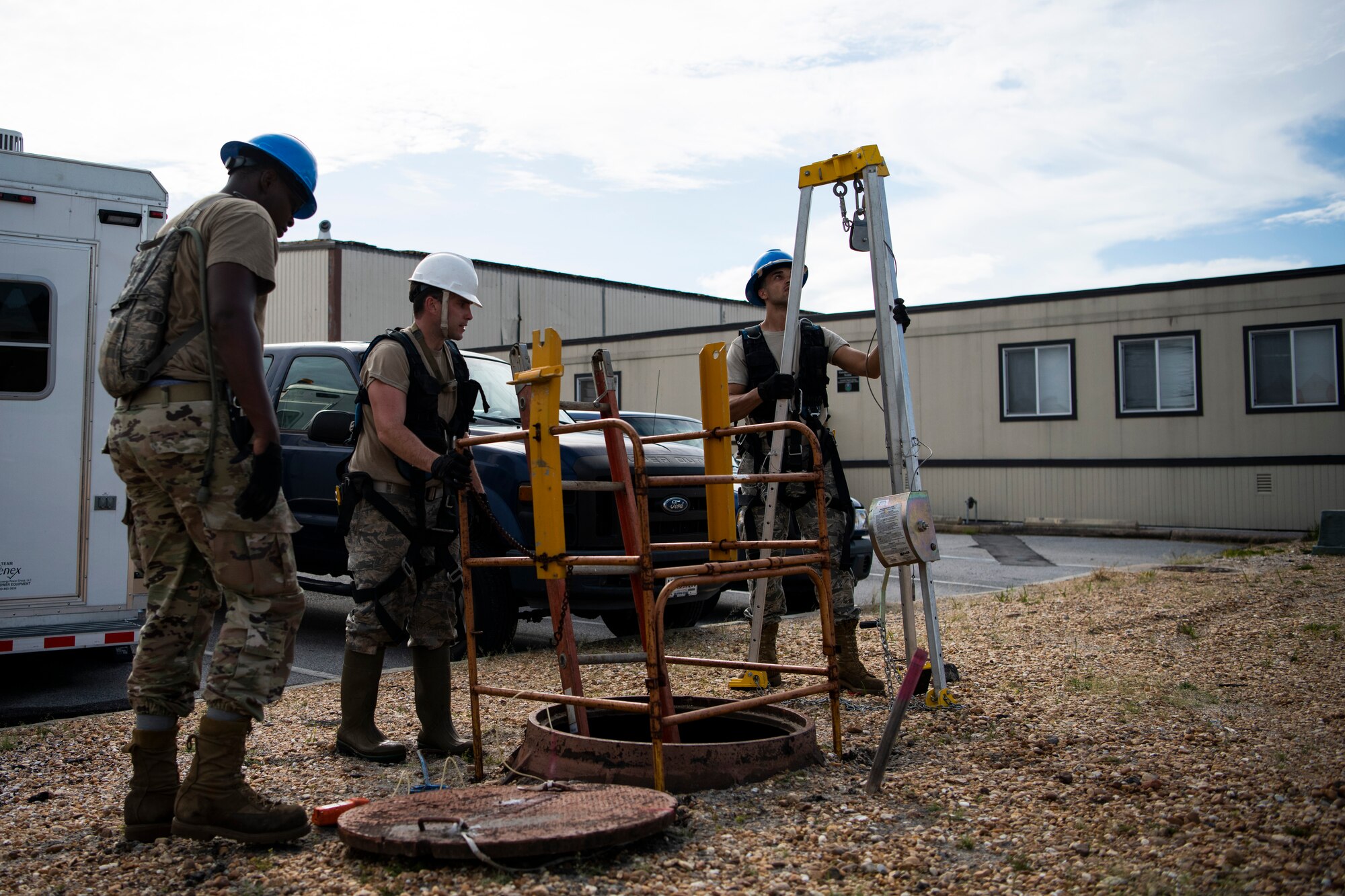 U.S. Air Force Senior Airman Darren Perry, left, Staff Sgt. Jesse Laclair, center, and Airman 1st Class Emmanuel Jackson-Wilson, right, cable antenna systems technicians with the 85th Engineering Installation Squadron assigned to Keesler Air Force Base, Mississippi, prepare to enter a manhole at Tyndall Air Force Base, Florida, Aug. 28, 2020. The 85th EIS has made multiple trips to Tyndall to assist the 325th Communications Squadron with relocating information transfer nodes. (U.S. Air Force photo by Tech. Sgt. Clayton Lenhardt)