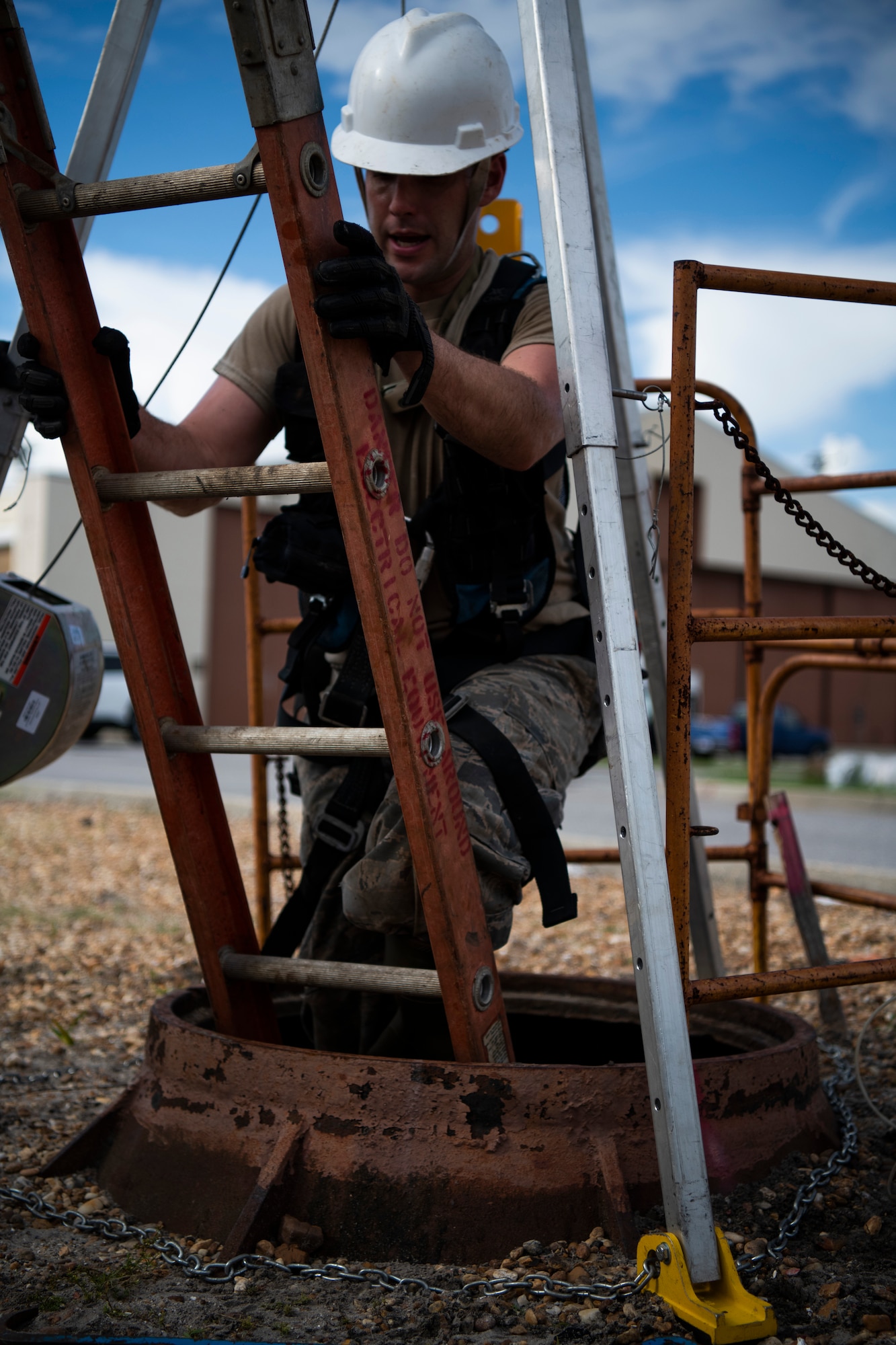 U.S. Air Force Staff Sgt. Jesse Laclair, cable antenna systems technician with the 85th Engineering Installation Squadron assigned to Keesler Air Force Base, Mississippi, enters a manhole to manage cable at Tyndall Air Force Base, Florida, Aug. 28, 2020. The 85th EIS has made multiple trips to Tyndall to assist the 325th Communications Squadron with relocating information transfer nodes. (U.S. Air Force photo by Tech. Sgt. Clayton Lenhardt)