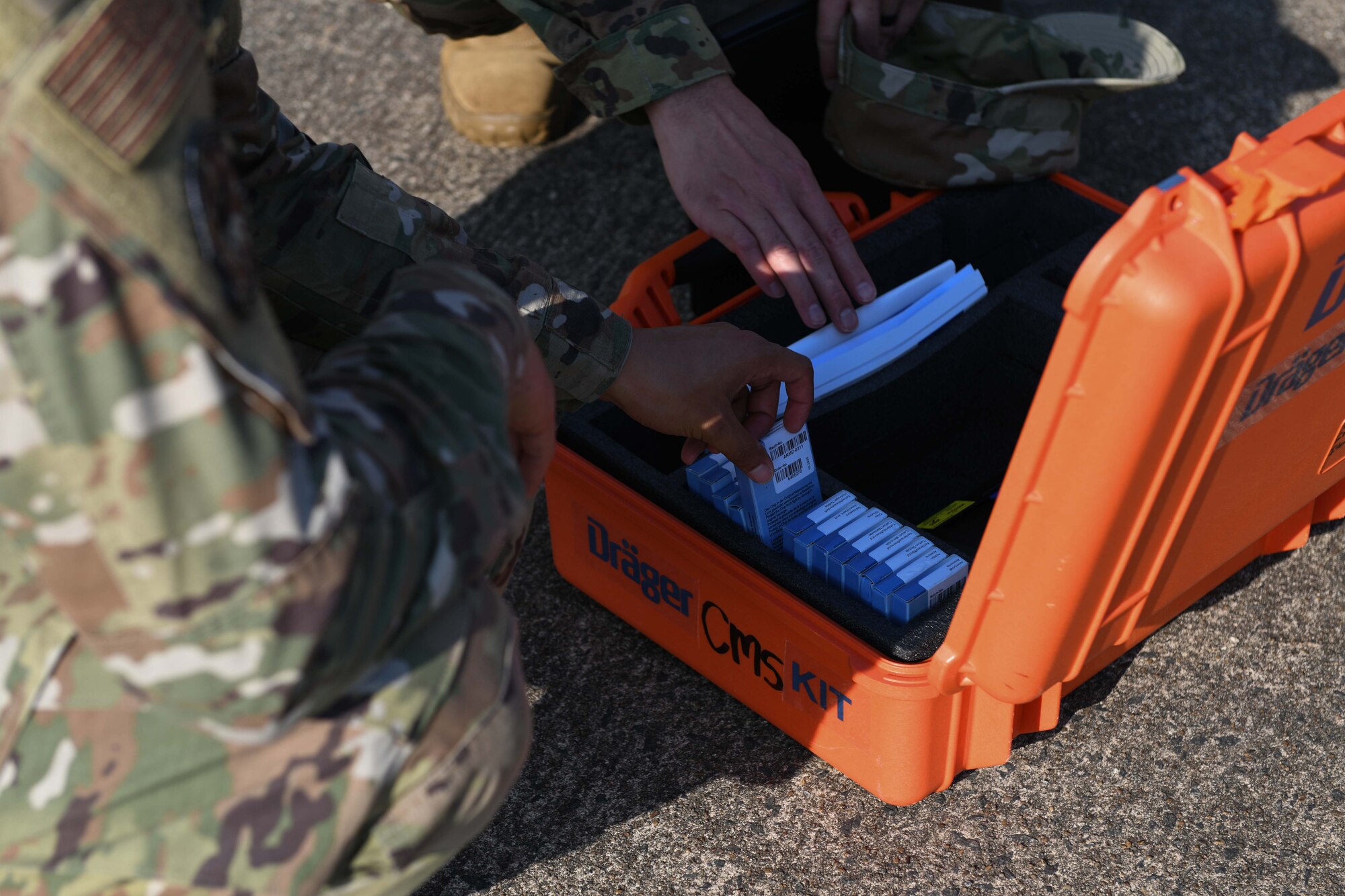 Airmen remove equipment from its case