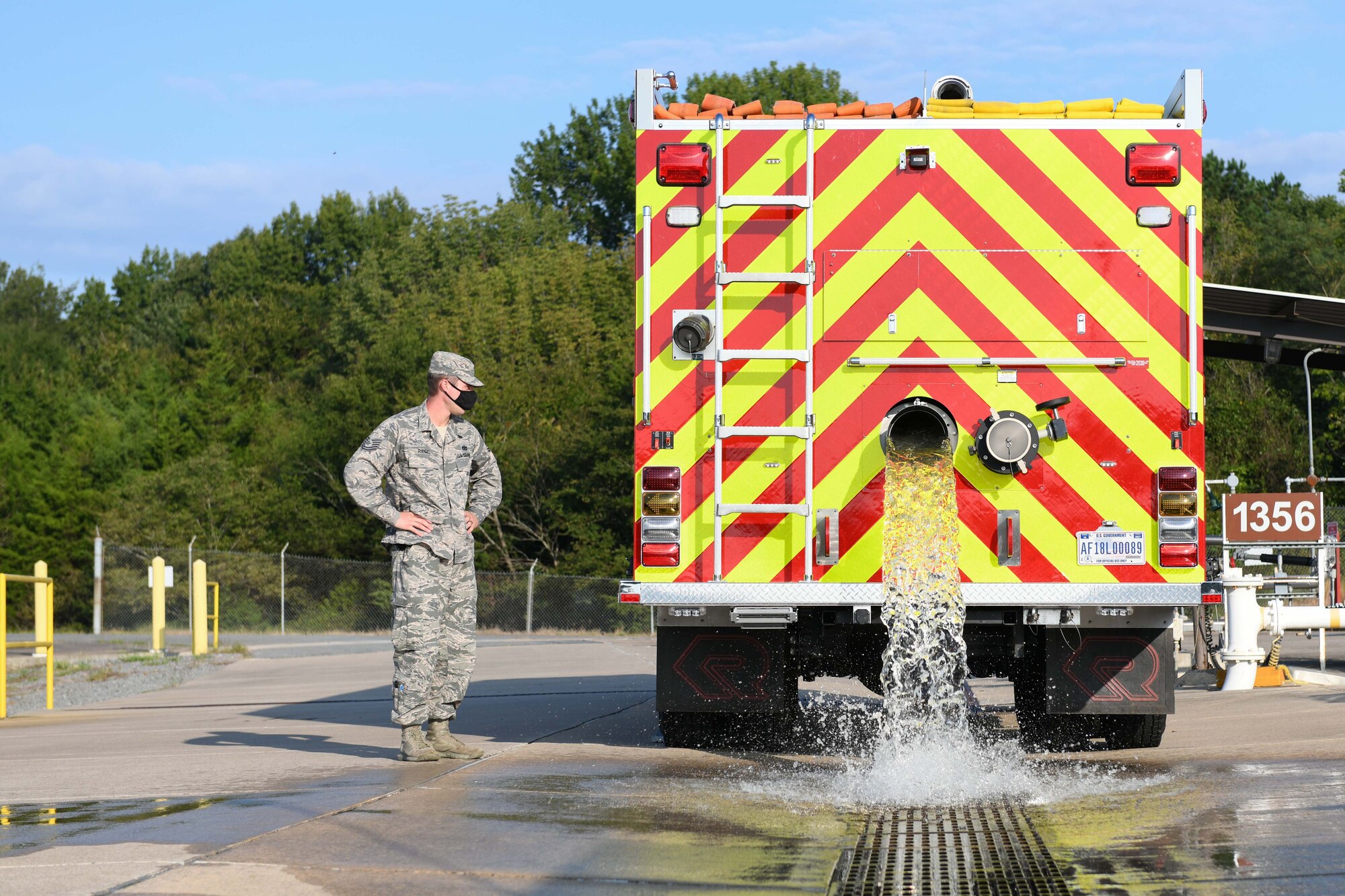 An Airman dumps water from a fire truck to simulate a fuel spill
