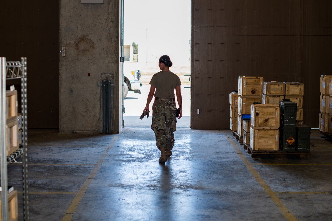 Senior Airman Marian Bock, 22nd Maintenance Squadron munitions flight custody accounts technician, exits an earth-covered magazine facility, or igloo, after performing inventory inspections Aug. 28, 2020, at McConnell Air Force Base, Kansas. Certain types of ammunition have to be stored in these earth covered facilities to meet safety regulations. (U.S. Air Force photo by Senior Airman Skyler Combs)