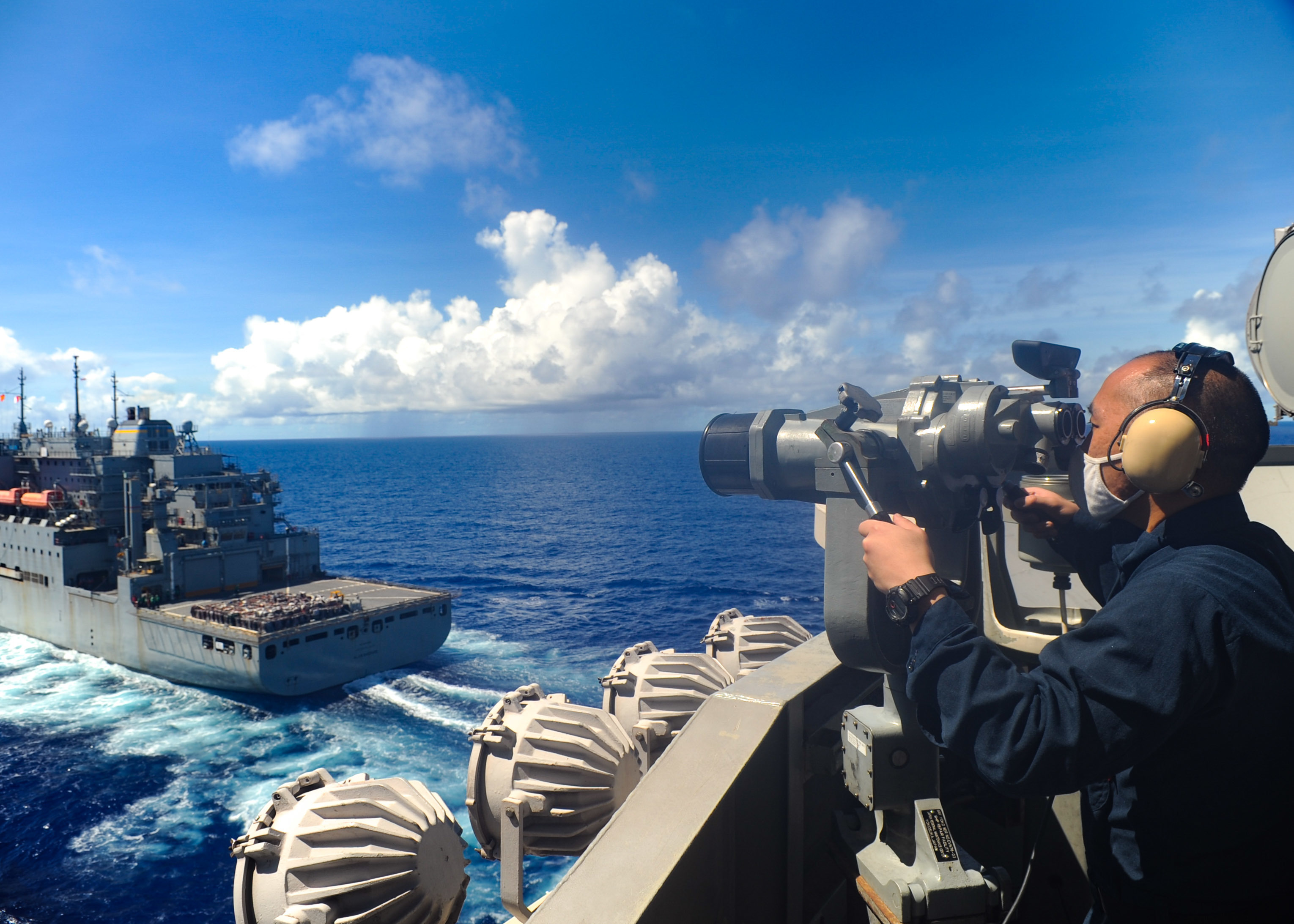 A Sailor stands lookout watch on the signal bridge as USS Ronald Reagan (CVN 76) approaches the dry cargo/ammunition ship USNS Allen Shepherd (T-AKE 3) during a replenishment-at-sea.