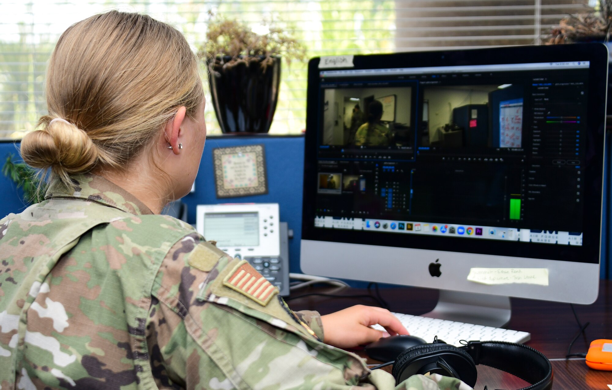 A photo of an airman editing her video footage in Adobe premiere.