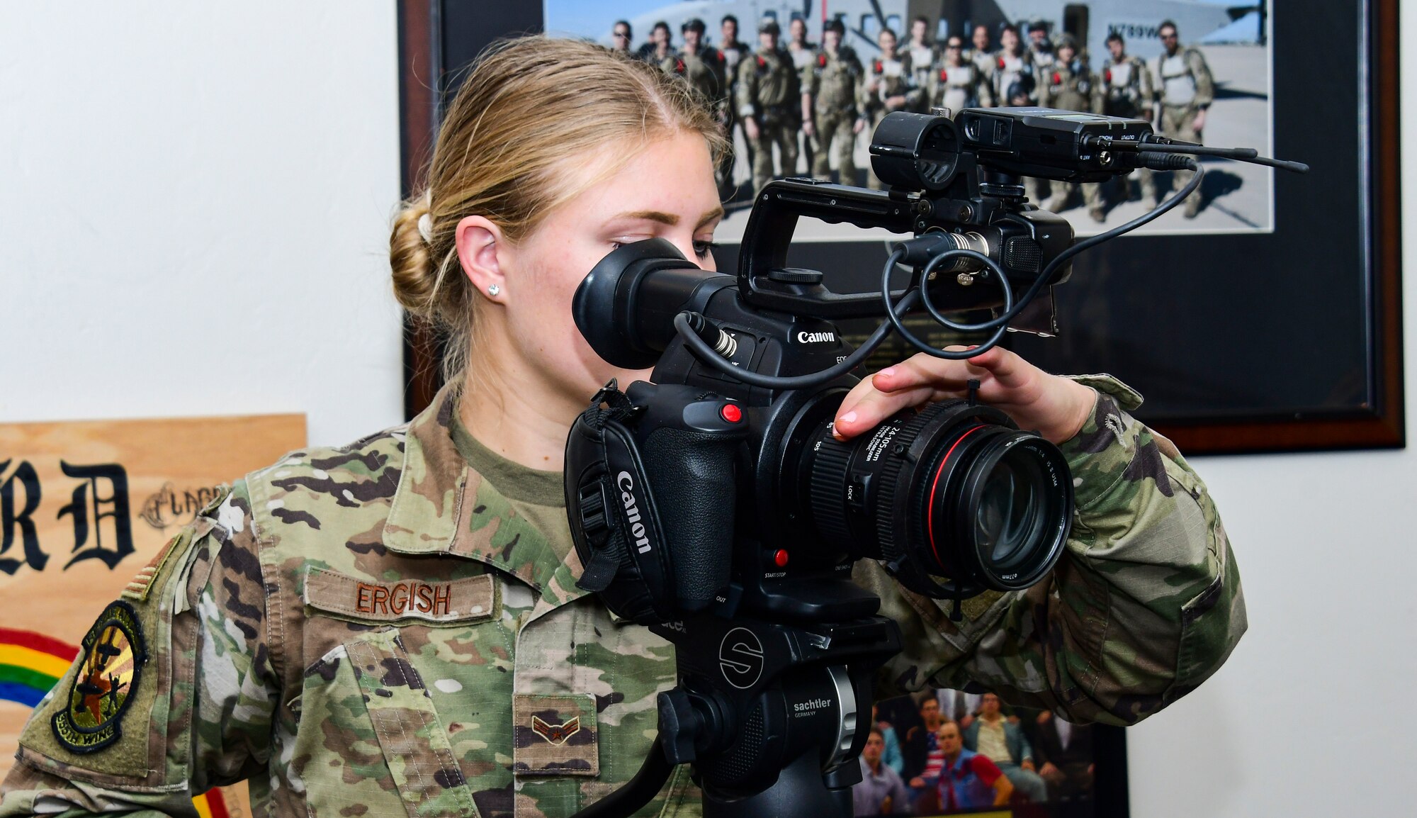 A photo of an airman getting her camera settings ready for an interview.