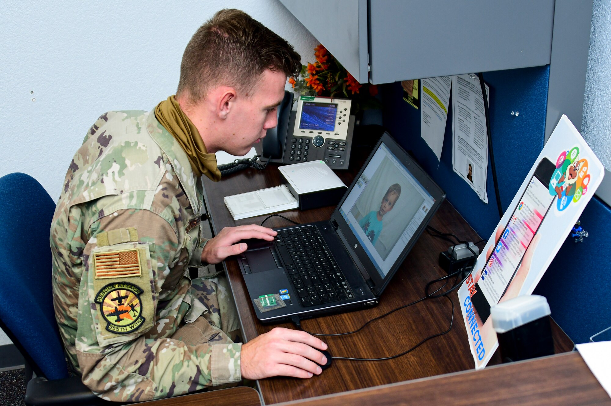 A photo of an airman getting ready to print a passport photo.