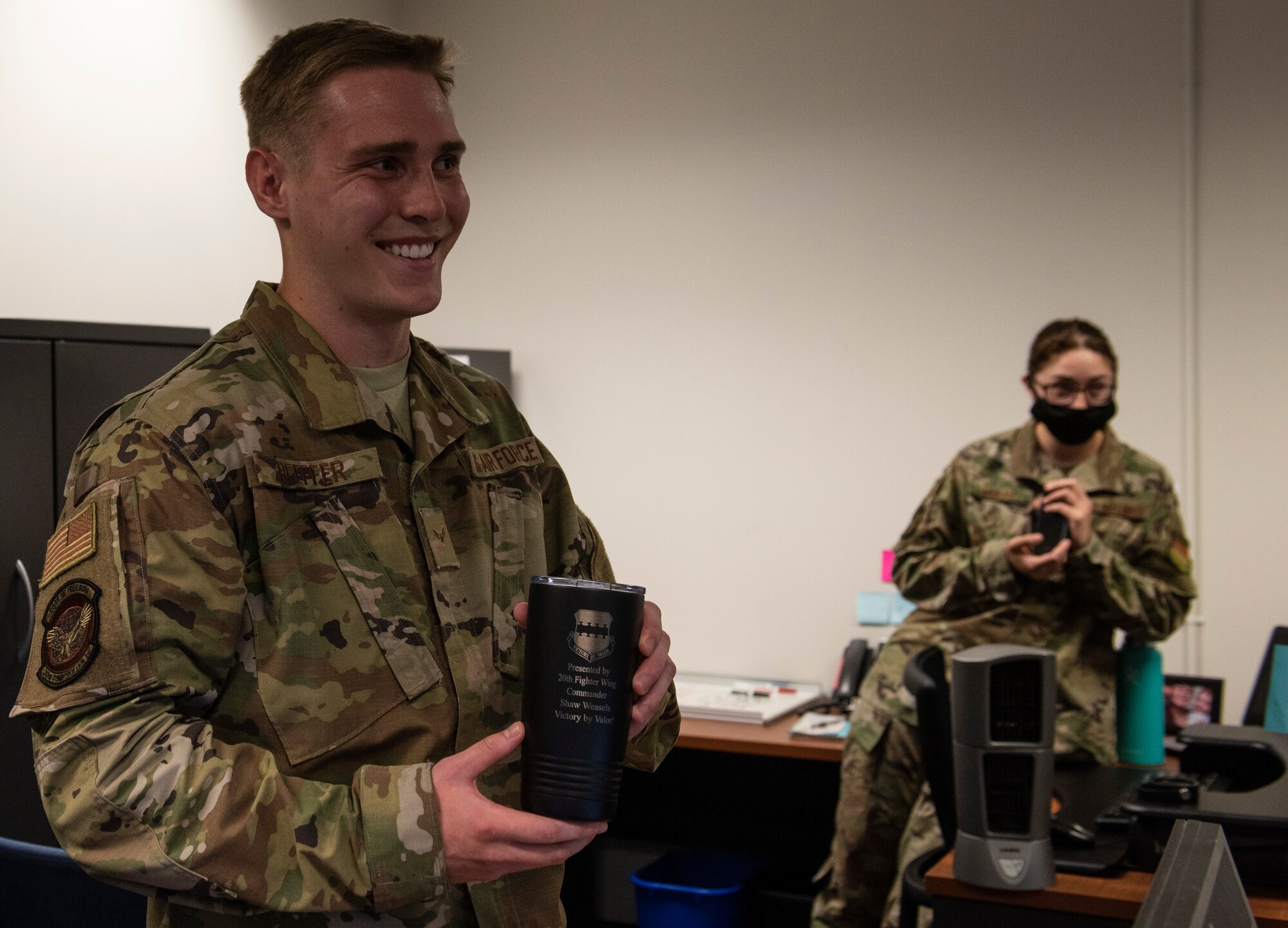 Image of an Airman accepting a Weasel of the Week award.