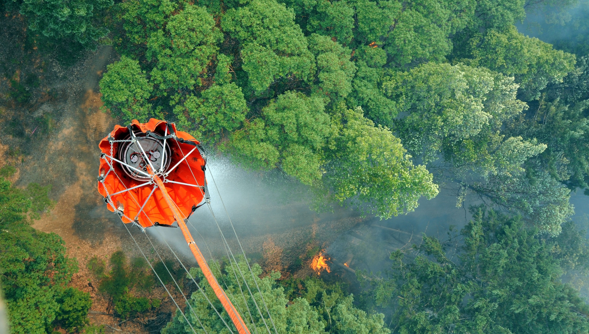 A National Guard helicopter drops water from a bucket onto a fire Aug. 23, 2020, in Healdsburg, California. This bucket has a 660-gallon capacity.