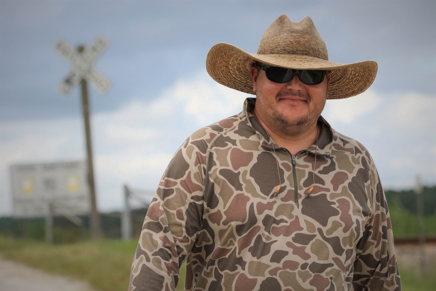 Man wears hat and smiles at camera