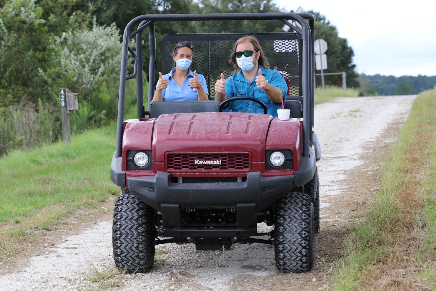 Man and women ride golf cart in a field
