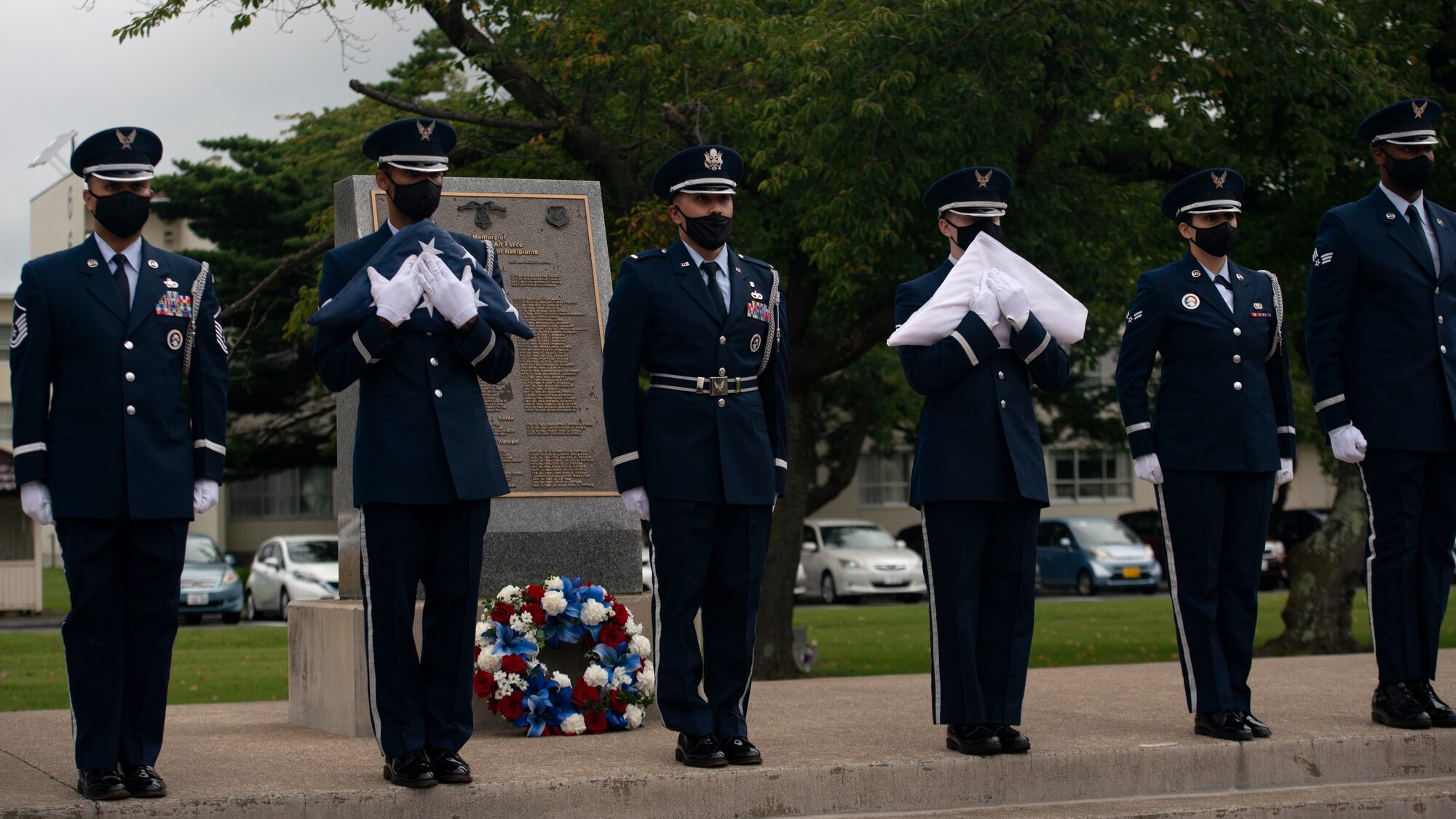 Individuals in uniform participate in an outdoor ceremony