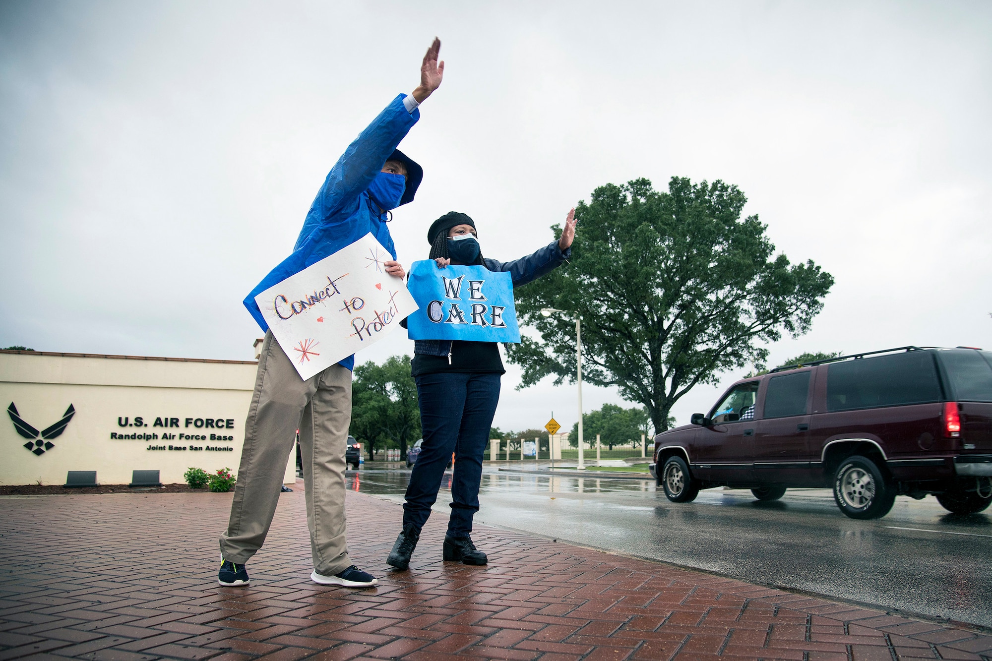 Dr. Aaron Moffett (left), 502nd Security Forces Group community support coordinator, and Dana Lockridge (right), Air Force Personnel Center, wave at people driving past them during the “We Care” event at Joint Base San Antonio-Randolph Sept. 10.