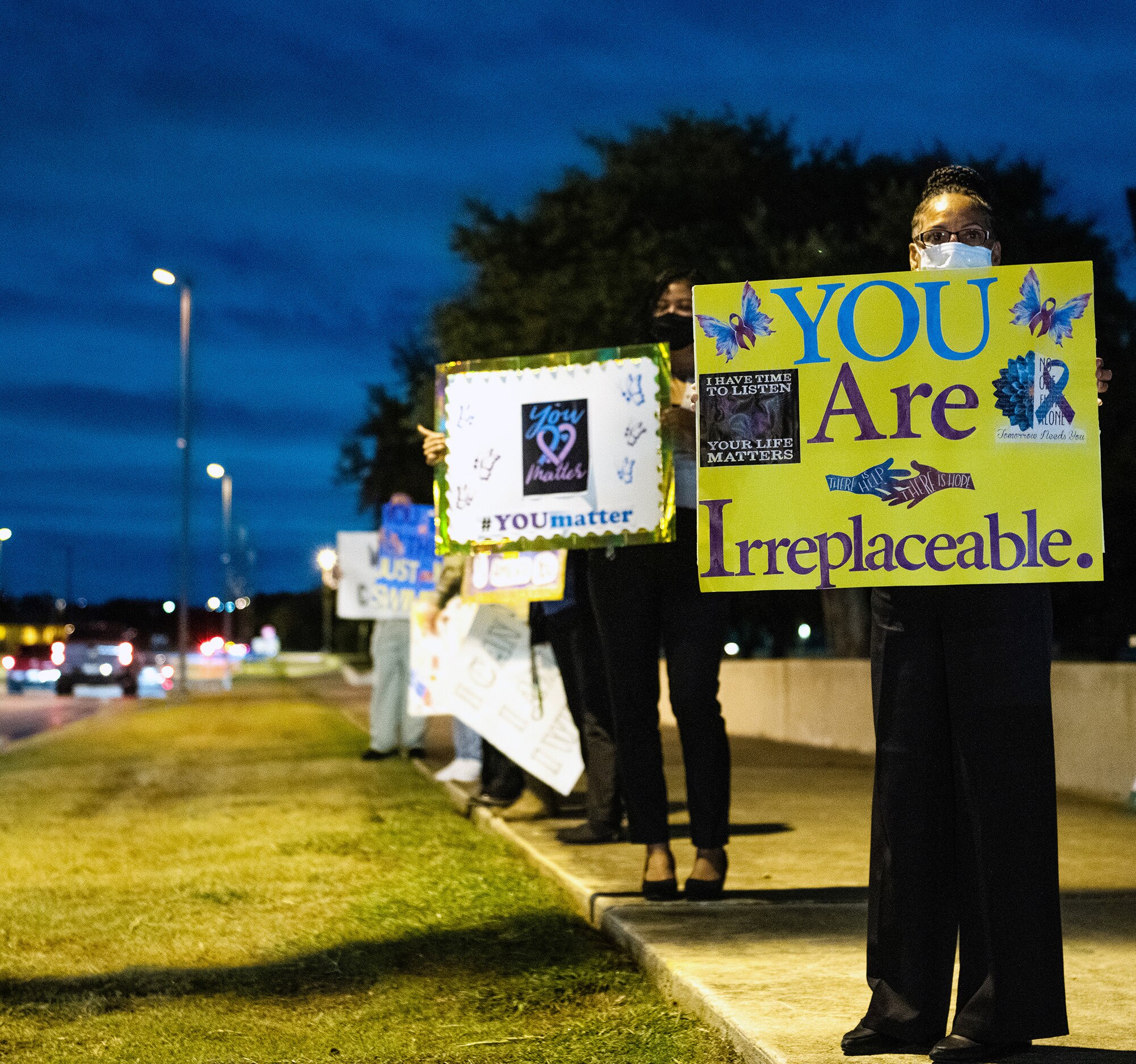 Volunteers at Joint Base San Antonio-Lackland hold signs in support of the We Care Day event Sept. 10. We Care Day is part of the Airman Comprehensive Fitness program that focuses on suicide awareness to assure wellness through prevention, education and intervention.