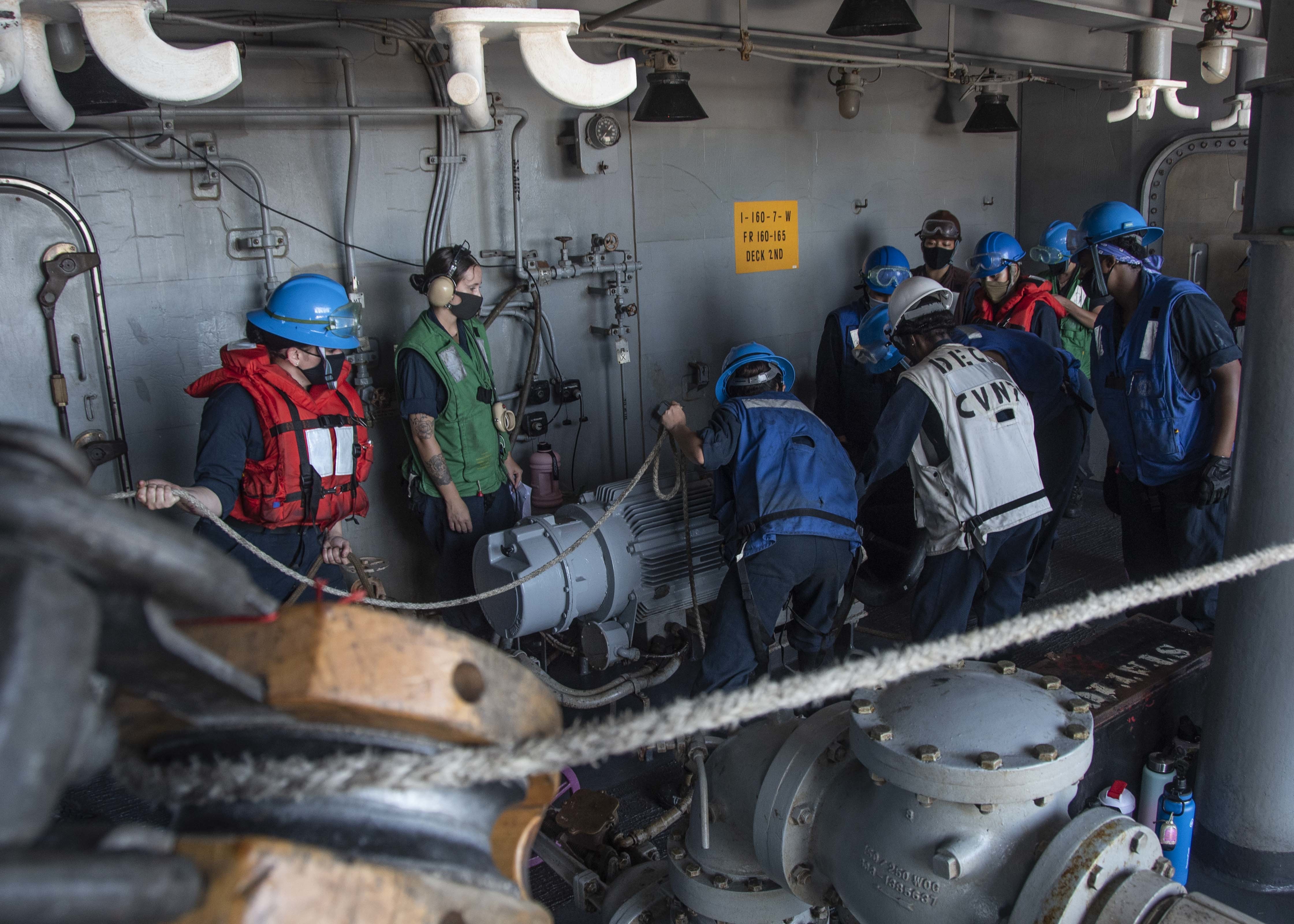 Sailors assigned to deck department handle line in a fueling station of the Navy’s only forward-deployed aircraft carrier USS Ronald Reagan (CVN 76) during a replenishment-at-sea with fleet replenishment oiler USNS Tippecanoe (T-AO 199).
