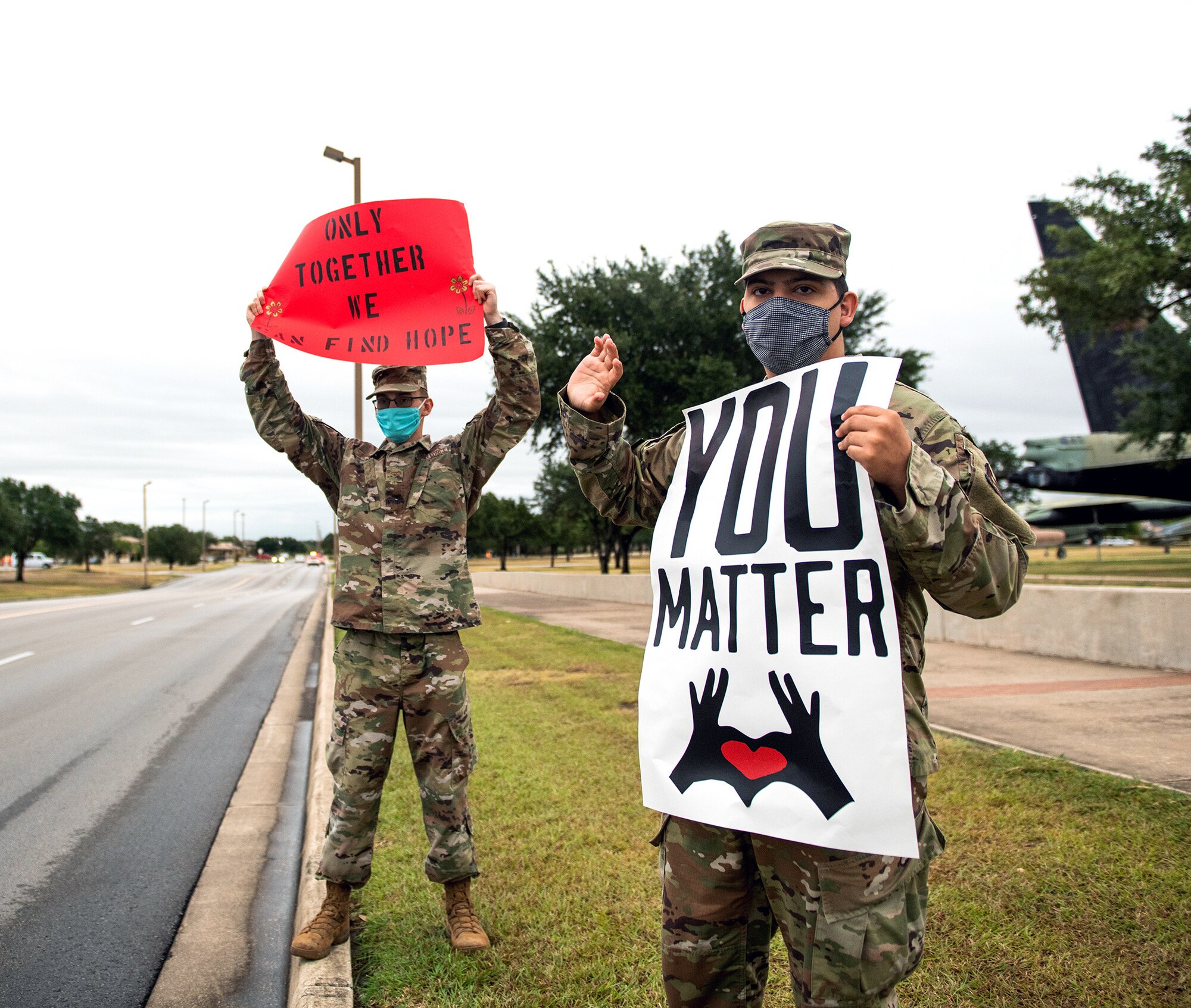 Volunteers at Joint Base San Antonio-Lackland hold signs in support of the We Care Day event Sept. 10, 2020.