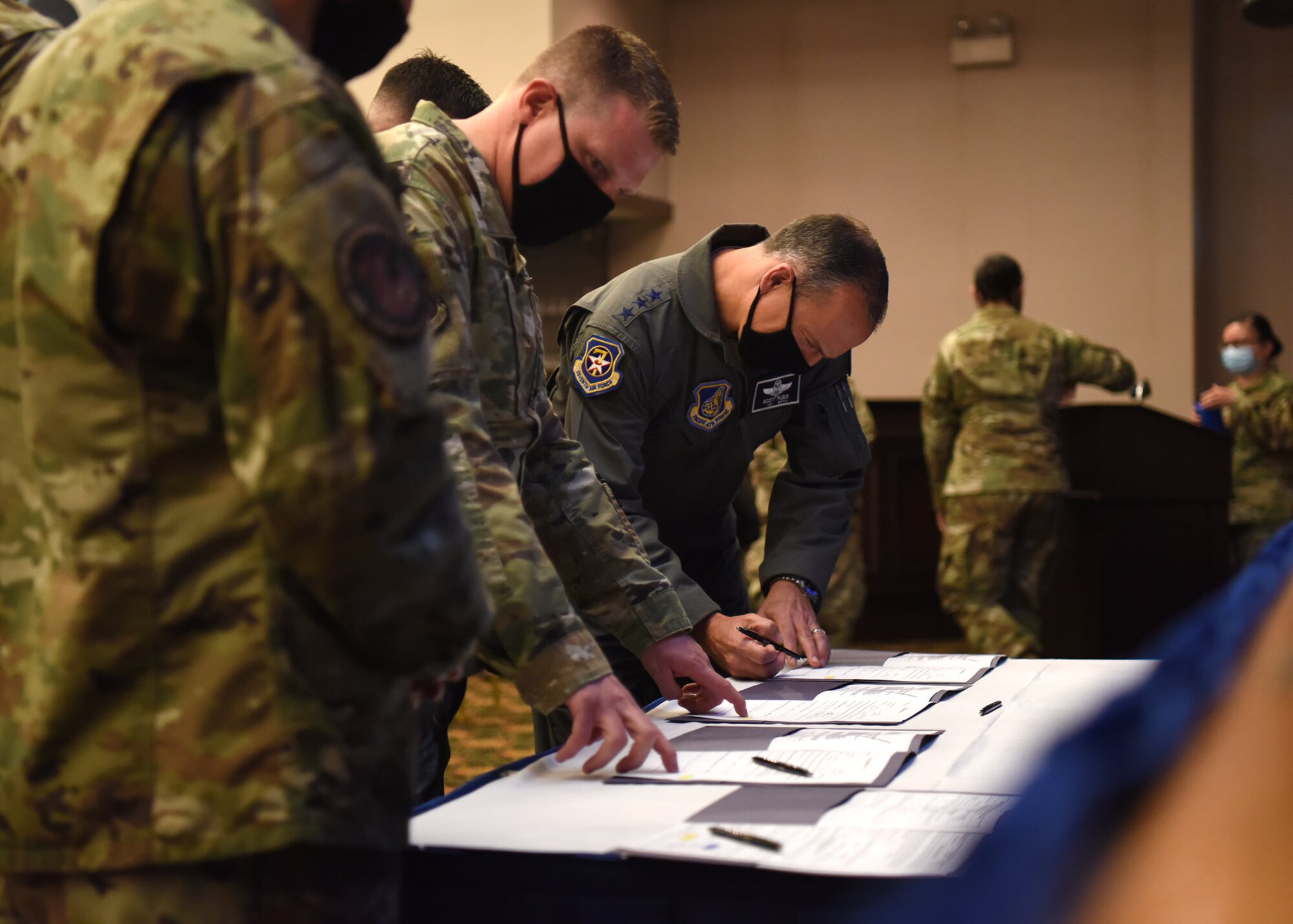 Lieutenant Gen. Scott Pleus, 7th Air Force commander, signs enlistment paperwork for four members of the 18th Intelligence Squadron , Detachment 2, during a U.S. Space Force transition ceremony on Osan Air Base, Republic of Korea, Sept. 14, 2020. Airmen serving in organic space specialties were called to volunteer for transition into the USSF to begin shifting their mindset into operating and winning in the space domain. (U.S. Air Force photo by Senior Airman Denise Jenson)