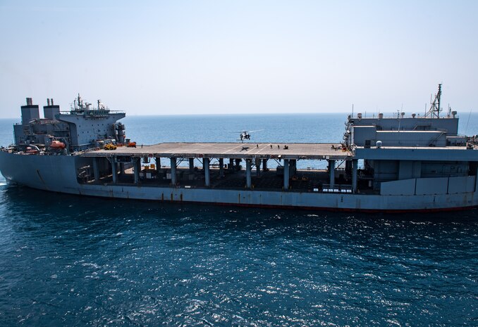 Explosive ordnance disposal technicians, assigned to Commander, Task Force (CTF) 56, fast-rope from an MH-60S Sea Hawk helicopter, attached to Helicopter Sea Combat Squadron (HSC) 26, onto the expeditionary mobile base USS Lewis B. Puller (ESB 3) during a fast-rope training evolution in the Arabian Gulf.