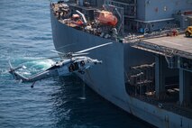 Explosive ordnance disposal technicians, assigned to Commander, Task Force (CTF) 56, prepare to fast-rope from an MH-60S Sea Hawk helicopter, attached to Helicopter Sea Combat Squadron (HSC) 26, onto the expeditionary mobile base USS Lewis B. Puller (ESB 3) during a fast-rope training evolution in the Arabian Gulf.