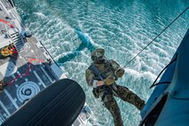 An explosive ordnance disposal technician, assigned to Commander, Task Force (CTF) 56, is hoisted from a Mark VI patrol boat into an MH-60S Sea Hawk helicopter, attached to Helicopter Sea Combat Squadron (HSC) 26, during hoist training operations in the Arabian Gulf.