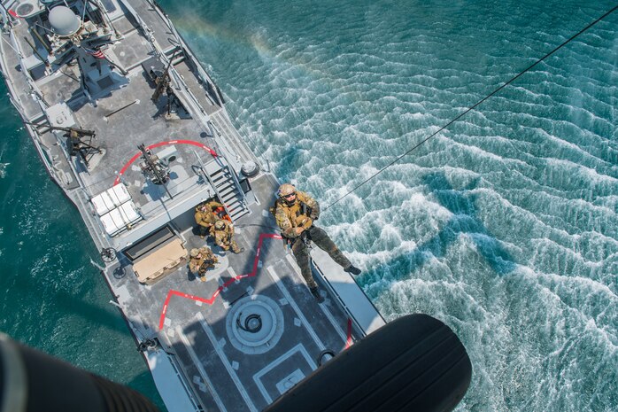 An explosive ordnance disposal technician, assigned to Commander, Task Force (CTF) 56, is hoisted from a Mark VI patrol boat into an MH-60S Sea Hawk helicopter, attached to Helicopter Sea Combat Squadron (HSC) 26, during hoist training operations in the Arabian Gulf.