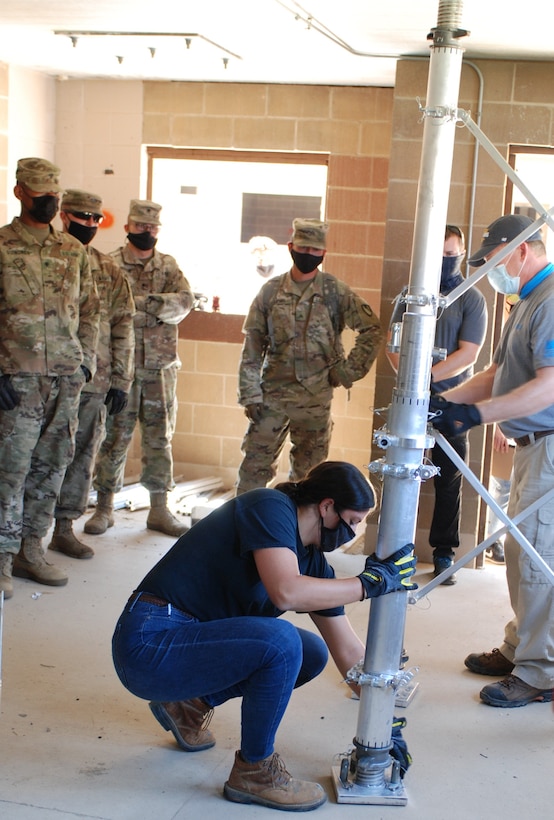Dr. Genenvieve Pezzola, a U.S. Army Engineer Research and Development Center (ERDC) research civil engineer and team leader for the Expedient Retrofit for Existing Buildings (EREB) system, carefully shows Soldiers from the 5th Engineer Battalion how to properly secure each piece of the EREB system. During the Maneuver Support, Sustainment and Protection Integration Experiments-2020, or MSSPIX-20, demonstrations, researchers from the ERDC tested three different protection technologies and demonstrated the capability of each system, collected data and validated the performance and new system upgrades at Training Area 230 on Fort Leonard Wood, Mo., Aug. 17, 2020.