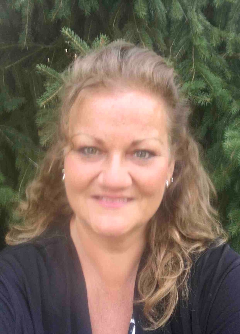 Tracy Hart headshot with a tree in background.