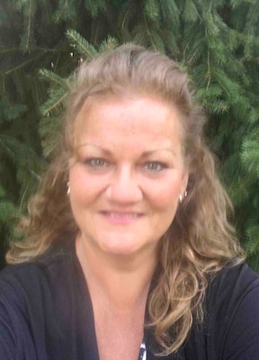 Tracy Hart headshot with a tree in background.