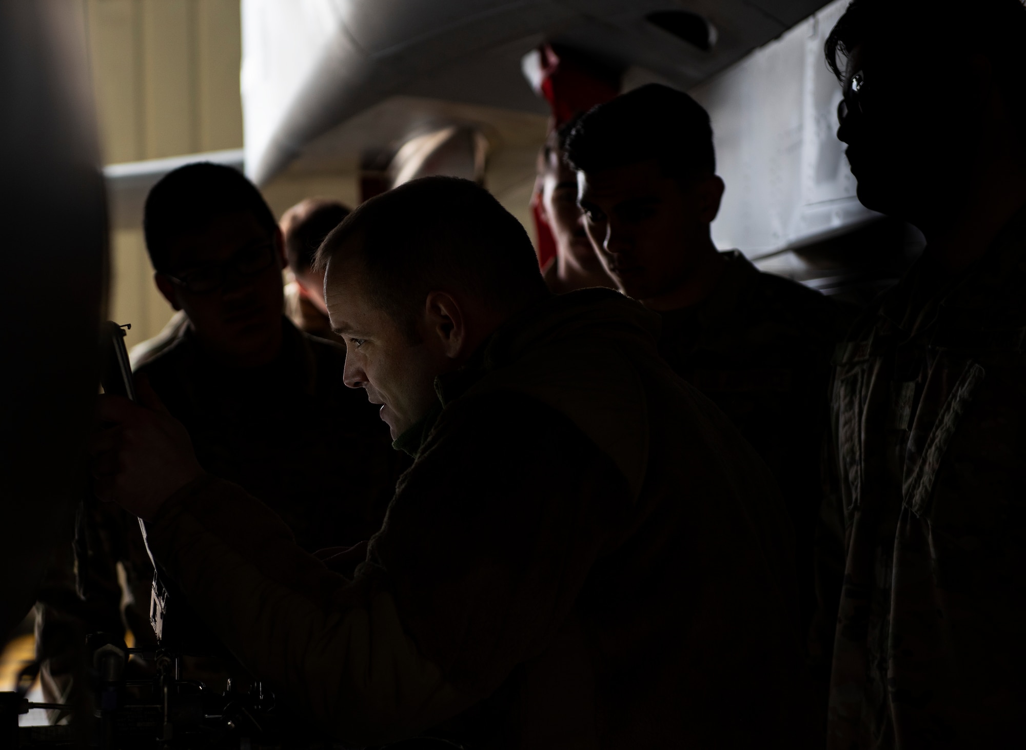 U.S. Air Force Airmen, assigned to the 48th Component Maintenance Squadron fuels systems maintenance shop, learn how to attach an external fuel tank to an F-15C Eagle during an Agile Combat Employment training at Royal Air Force Lakenheath, England, Aug. 31, 2020. Proficiency in a multitude of skills allows Airmen to more effectively and efficiently respond to unique scenarios and potential threats, which is a key aspect of the ACE initiative. (U.S. Air Force photo by Airman 1st Class Jessi Monte)