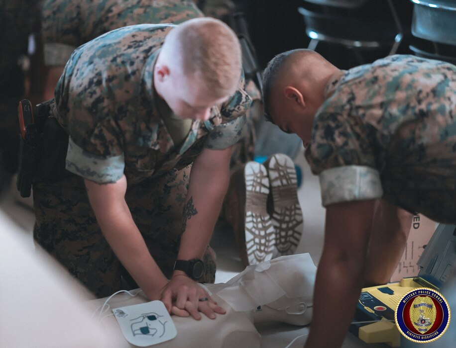Students of the Military Police Basic Course utilize an Automated External Defibrillator (AED) to administer Cardio Pulmonary Resuscitation (CPR) to a mannequin as they endeavor to earn their First Aid certification.