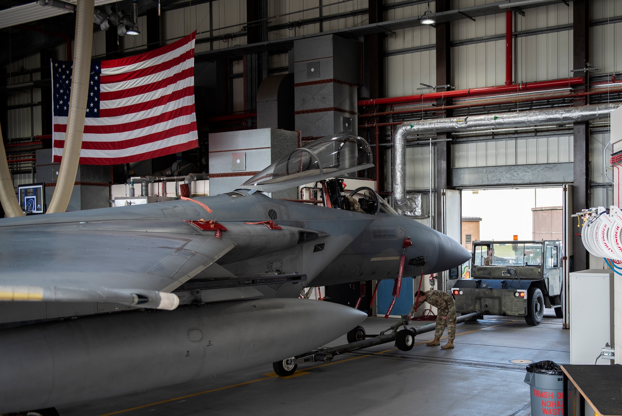 U.S. Air Force Airmen, assigned to the 48th Component Maintenance Squadron fuels shop, tow an F-15C Eagle into the hangar during an Agile Combat Employment training at Royal Air Force Lakenheath, England, Aug. 31, 2020. The training was designed to enhance ACE  capabilities by teaching Airmen to perform multiple roles outside the scope of their regular daily duties. (U.S. Air Force photo by Airman 1st Class Jessi Monte)
