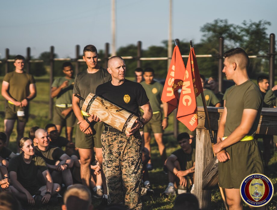 MSgt Hatfield, the Course Chief of the Military Police Basic Course, presents a memento to the class who won a physical fitness competition while competing against all other classes from the Marine Corps’ Military Police School.