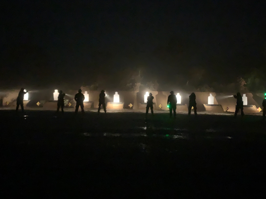 Students of the Military Police Basic Course conduct live-fire training in a low-light environment.