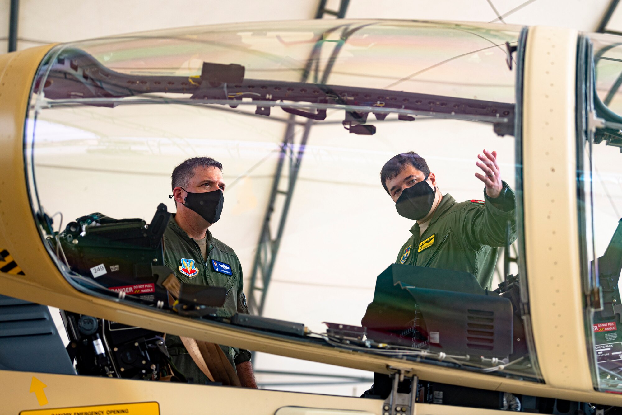 A photo of an Airman showing the 23d Wing commander an aircraft canopy
