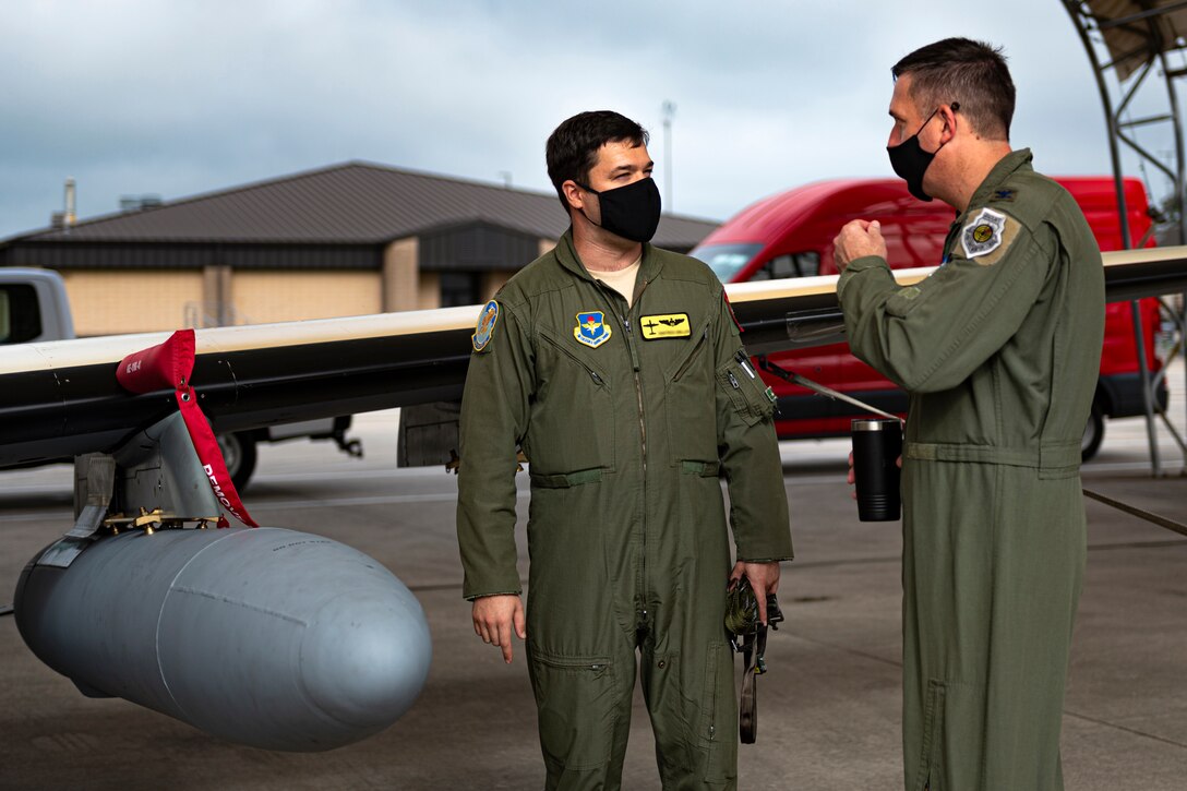 A photo of the 23d Wing commander speaking with an Airman