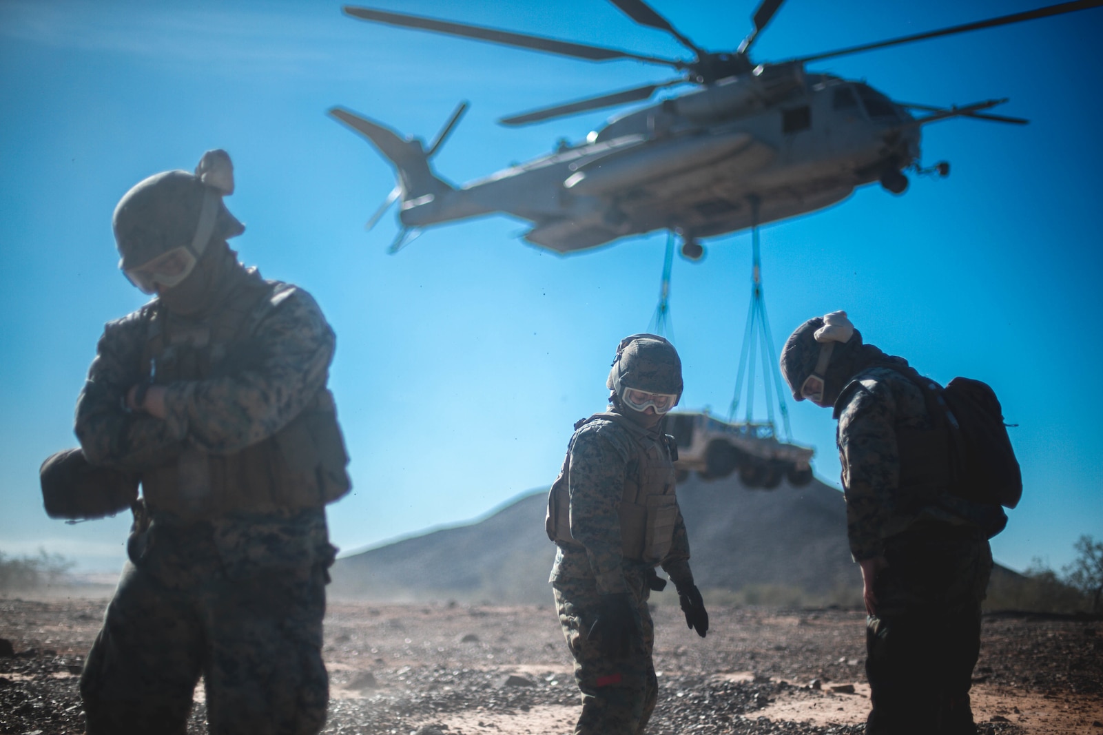 U.S. Marines with 1st Transportation Support Battalion, 1st Marine Logistics Group, ground themselves after a CH-53E Super Stallion from Marine Heavy Helicopter Squadron 465, 3rd Marine Aircraft Wing, lifts a Humvee during a helicopter support team training exercise in Yuma, Ariz., on Jan. 23, 2019.
