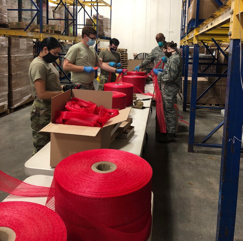 A group of Army and Air Force personnel working in a warehouse