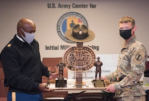 U.S. Army Staff Sgt. Erik A. Rostamo, (right), receives the Drill Sergeant of the Year award from Command Sgt. Maj. Edward Mitchell, Center for Initial Military Training, Sept. 10, 2020, at Fort Eustis, Virginia. The DSOY’s main role is to continuously review training guidance and regulations in order to mentor Army drill sergeants on lessons learned, training trends, and best courses of actions. (U.S. Air Force photo by Staff Sgt. Joshua Magbanua)