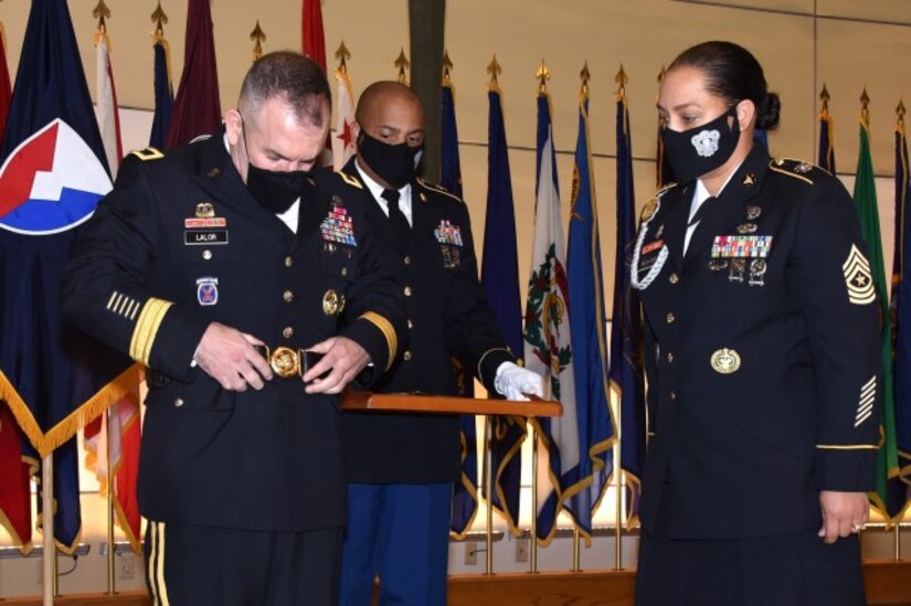 Army Medical Logistics Command Commander Brig. Gen. Michael Lalor, left, receives his general officer belt from Sgt. Maj. Monnet Bushner, right, during a promotion ceremony at Fort Detrick, Maryland, on Sept. 11. Sgt. 1st Class Brian Ockimey, center, holds the proffer tray. (Photo Credit: Ellen Crown)